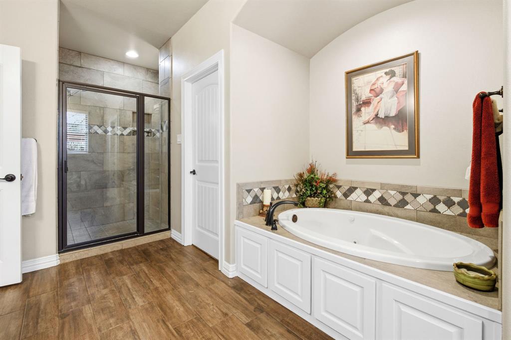 146 Mesquite Ridge Lane Lawn, TX 79530 - Photo 19 of 40 a bathroom with a tub a sink and glass door shower
