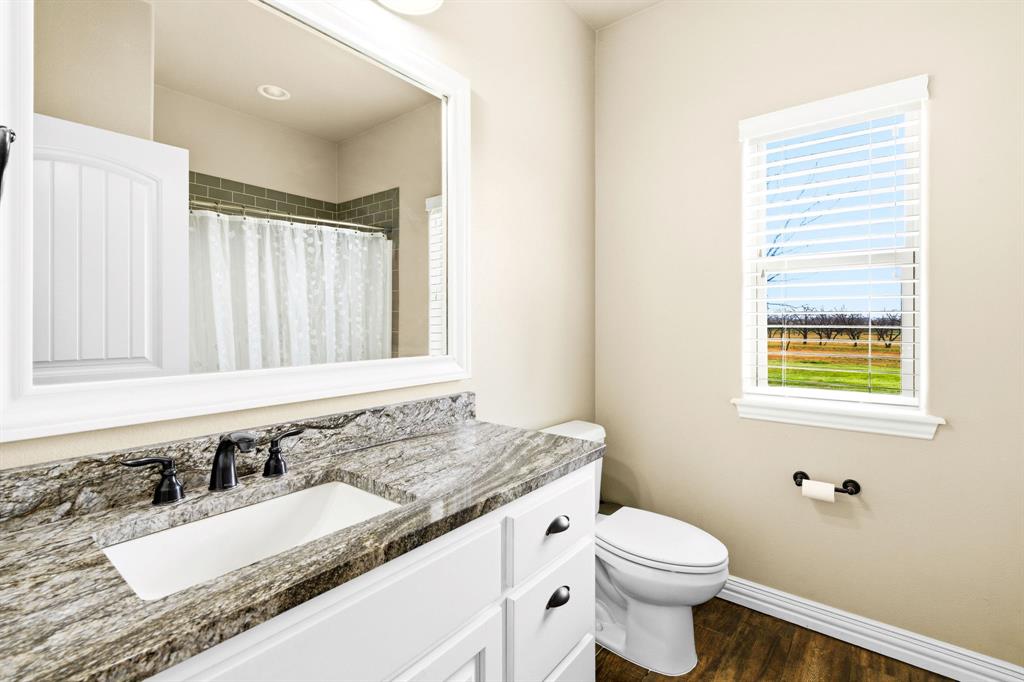146 Mesquite Ridge Lane Lawn, TX 79530 - Photo 23 of 40 a bathroom with a granite countertop sink toilet and mirror