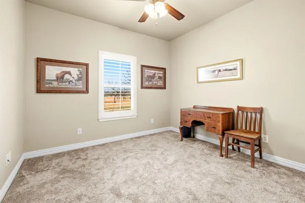 a view of a workspace with furniture and a window