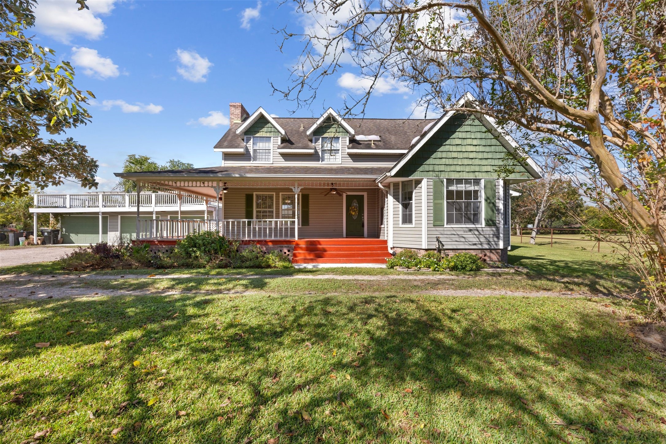 a view of a house with a big yard plants and large tree