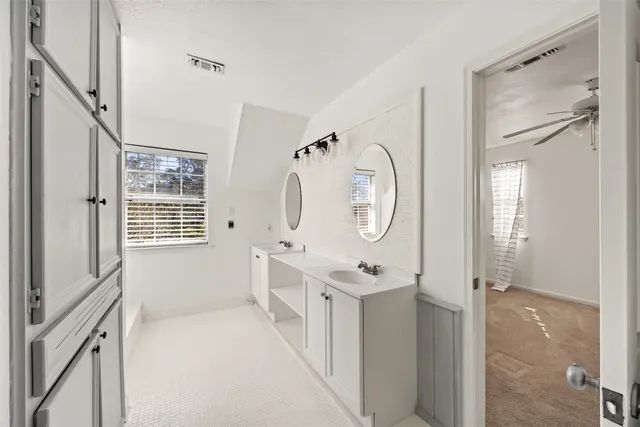 a spacious bathroom with a double vanity sink mirror and shower