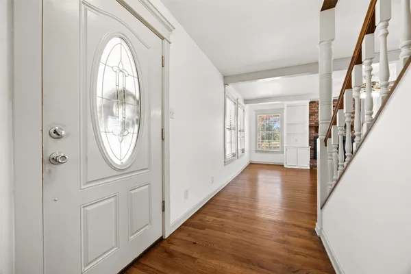 a view of a hallway with wooden floor and entryway