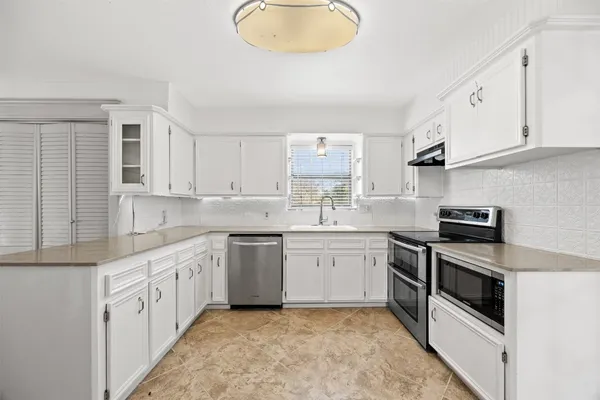 a kitchen with stainless steel appliances granite countertop a sink and a stove