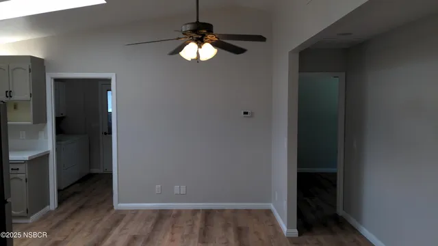 an empty room with wooden floor closet and chandelier