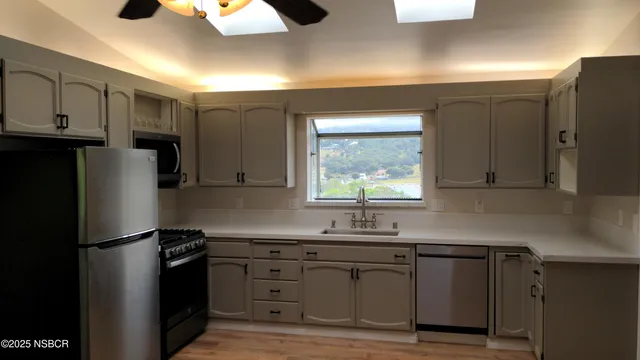 a kitchen with stainless steel appliances granite countertop a refrigerator sink and cabinets