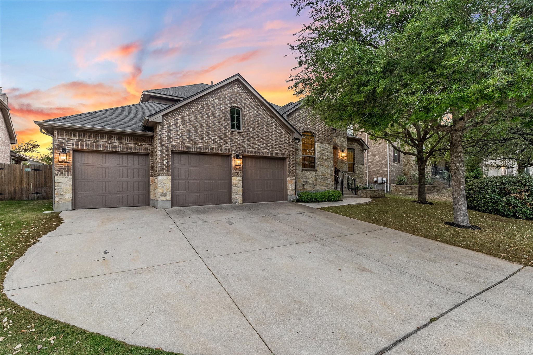 226 Galloway Lane Austin, TX 78737 - Photo 4 of 30 French country home featuring brick siding, driveway, a garage, roof with shingles, and stone siding