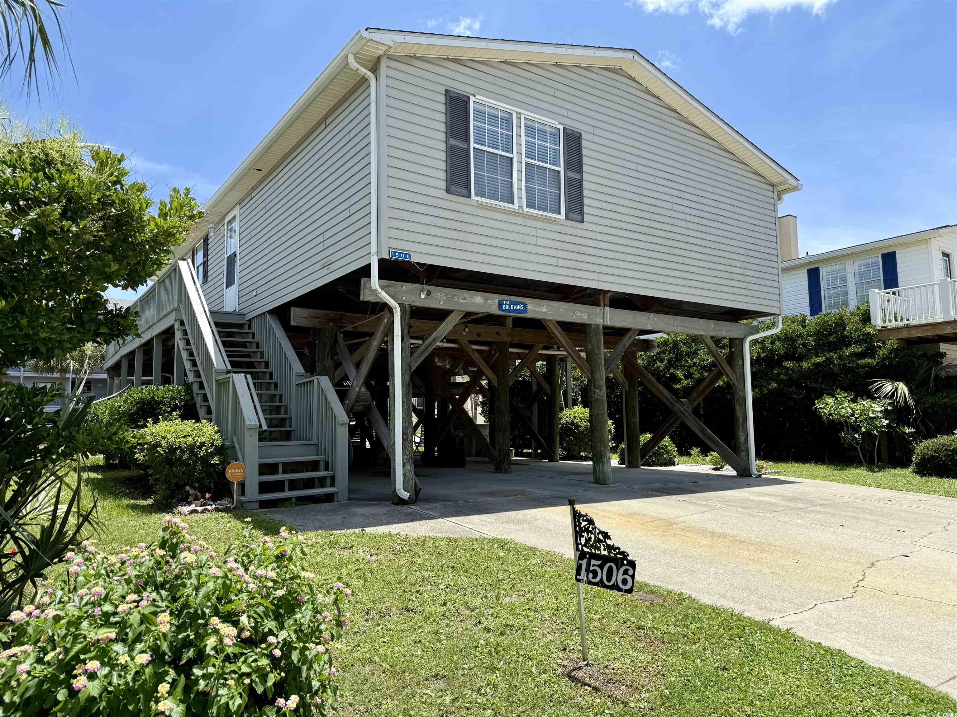 Exterior space with a carport, stairway, and concrete driveway