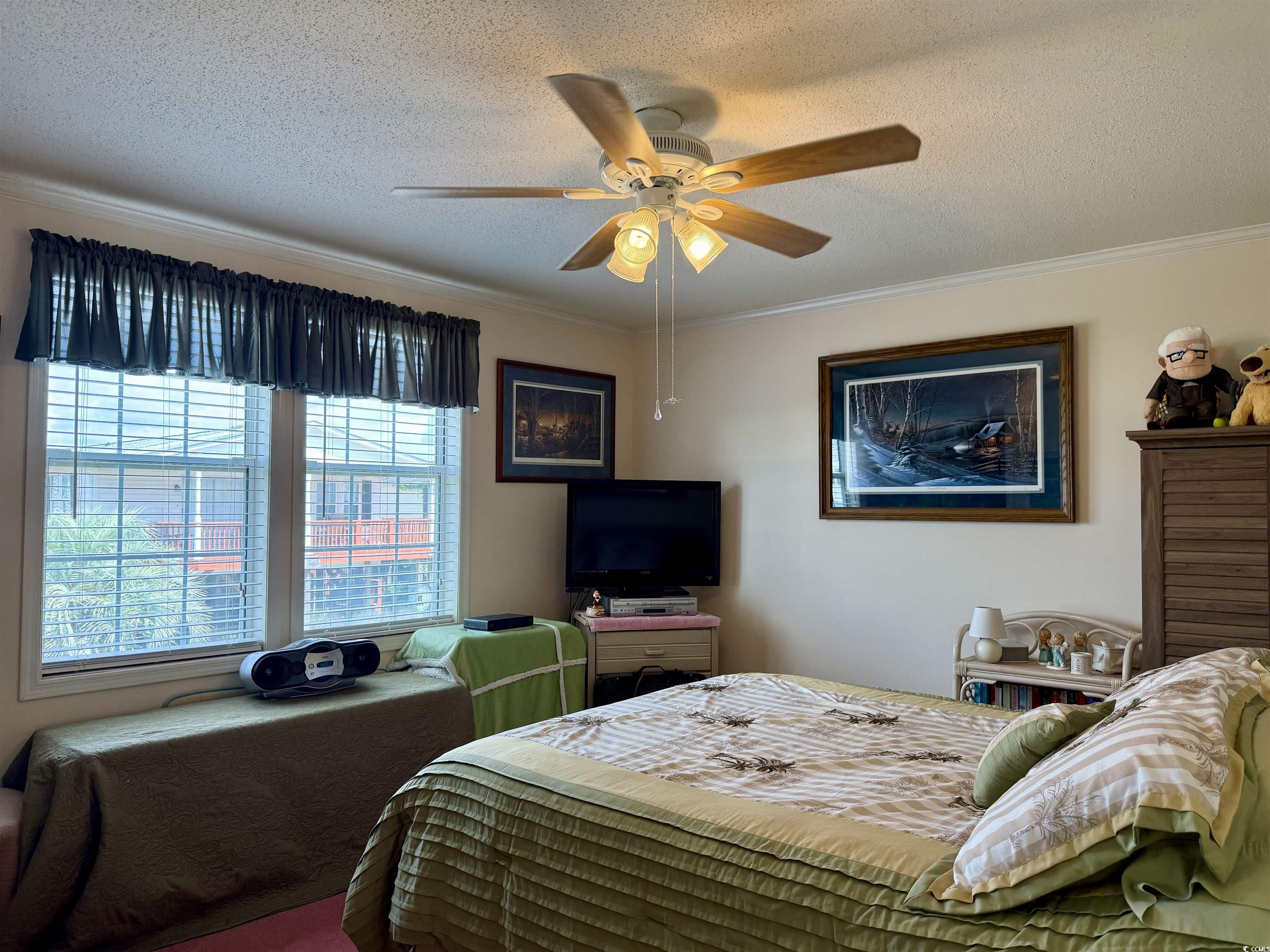 1506 Mason Circle Surfside Beach, SC 29575 - Photo 14 of 33 Bedroom with crown molding, a textured ceiling, and ceiling fan