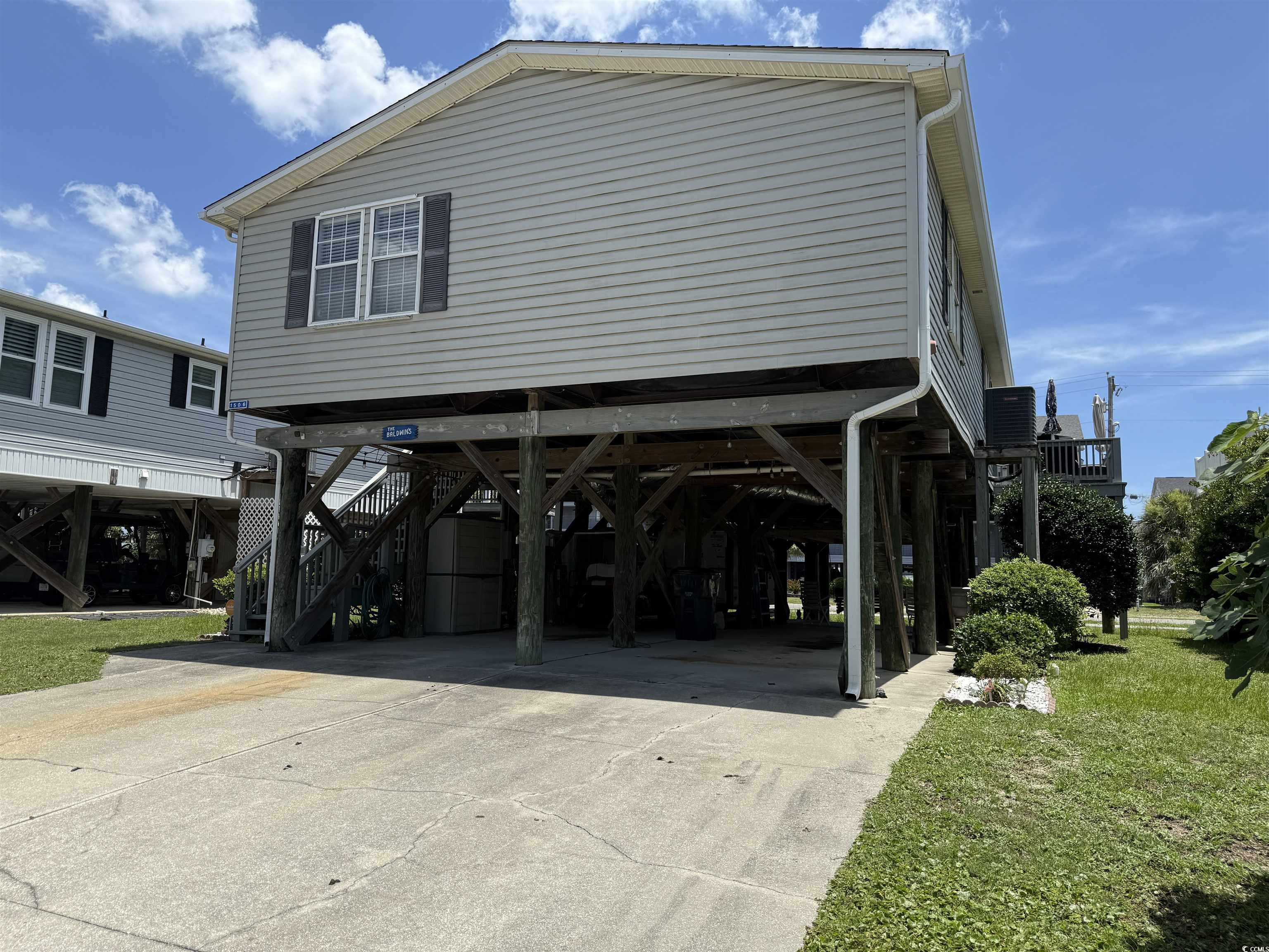 1506 Mason Circle Surfside Beach, SC 29575 - Photo 23 of 33 View of property exterior featuring a carport, stairs, driveway, and a lawn