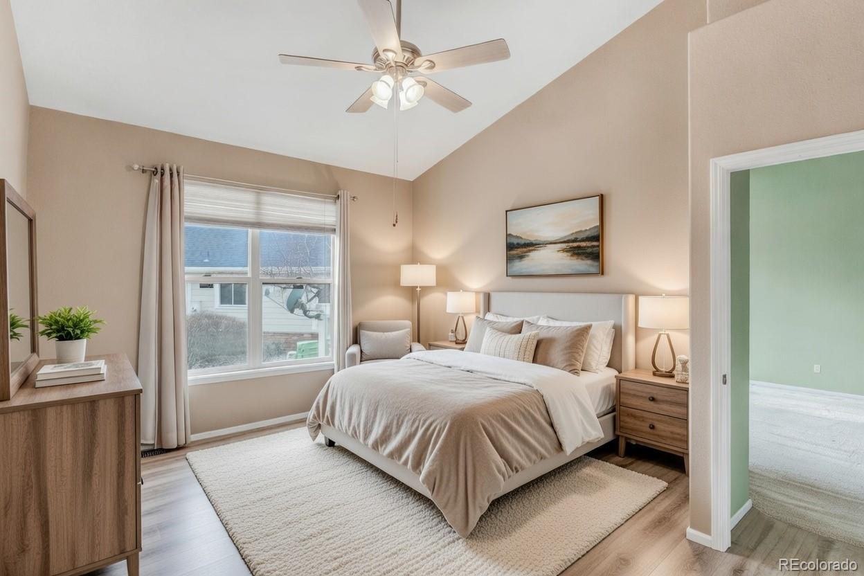 6656 South Reed Way, Unit B Littleton, CO 80123 - Photo 13 of 32 a bedroom with a large bed and a chandelier fan