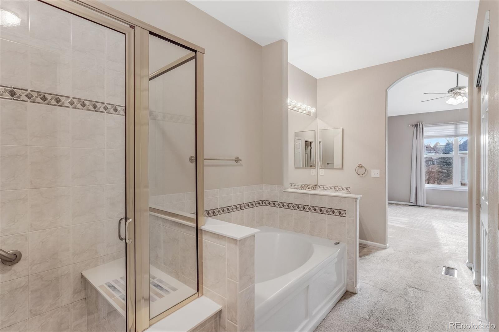 6656 South Reed Way, Unit B Littleton, CO 80123 - Photo 14 of 32 a spacious bathroom with a tub shower and sink