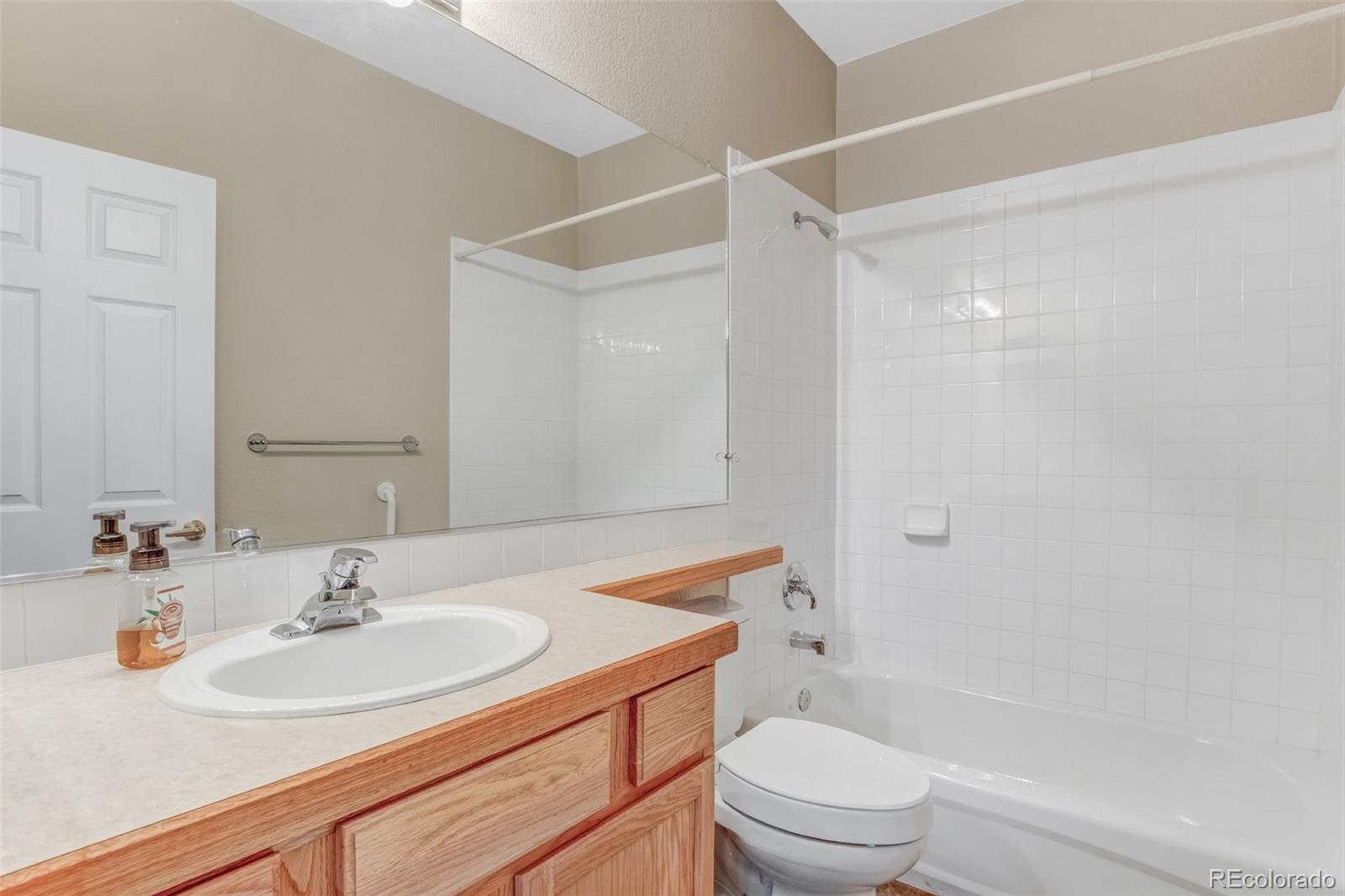 6656 South Reed Way, Unit B Littleton, CO 80123 - Photo 20 of 32 a bathroom with a sink a toilet and shower