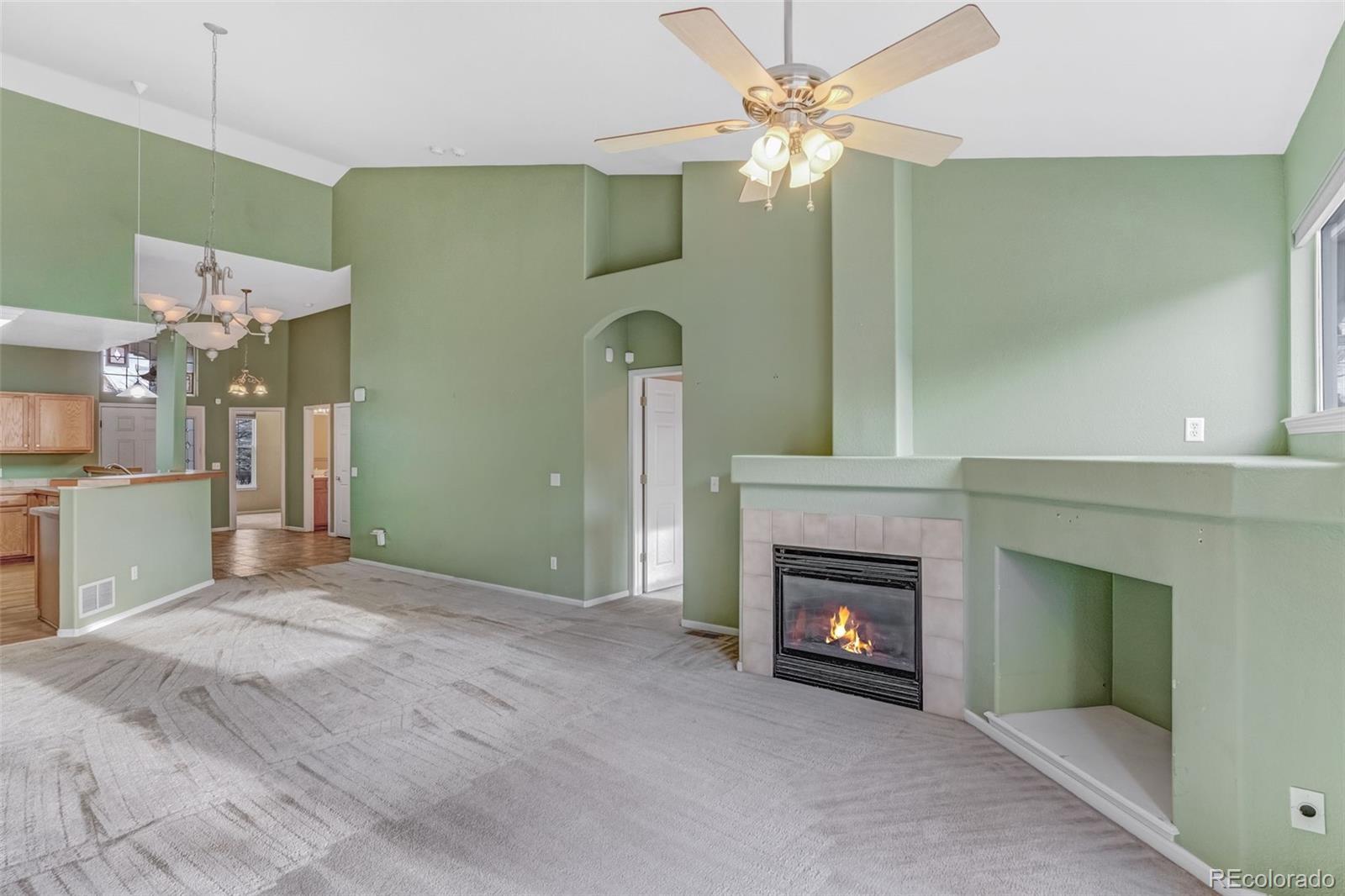 6656 South Reed Way, Unit B Littleton, CO 80123 - Photo 2 of 32 a view of an empty room with a fireplace and a fan