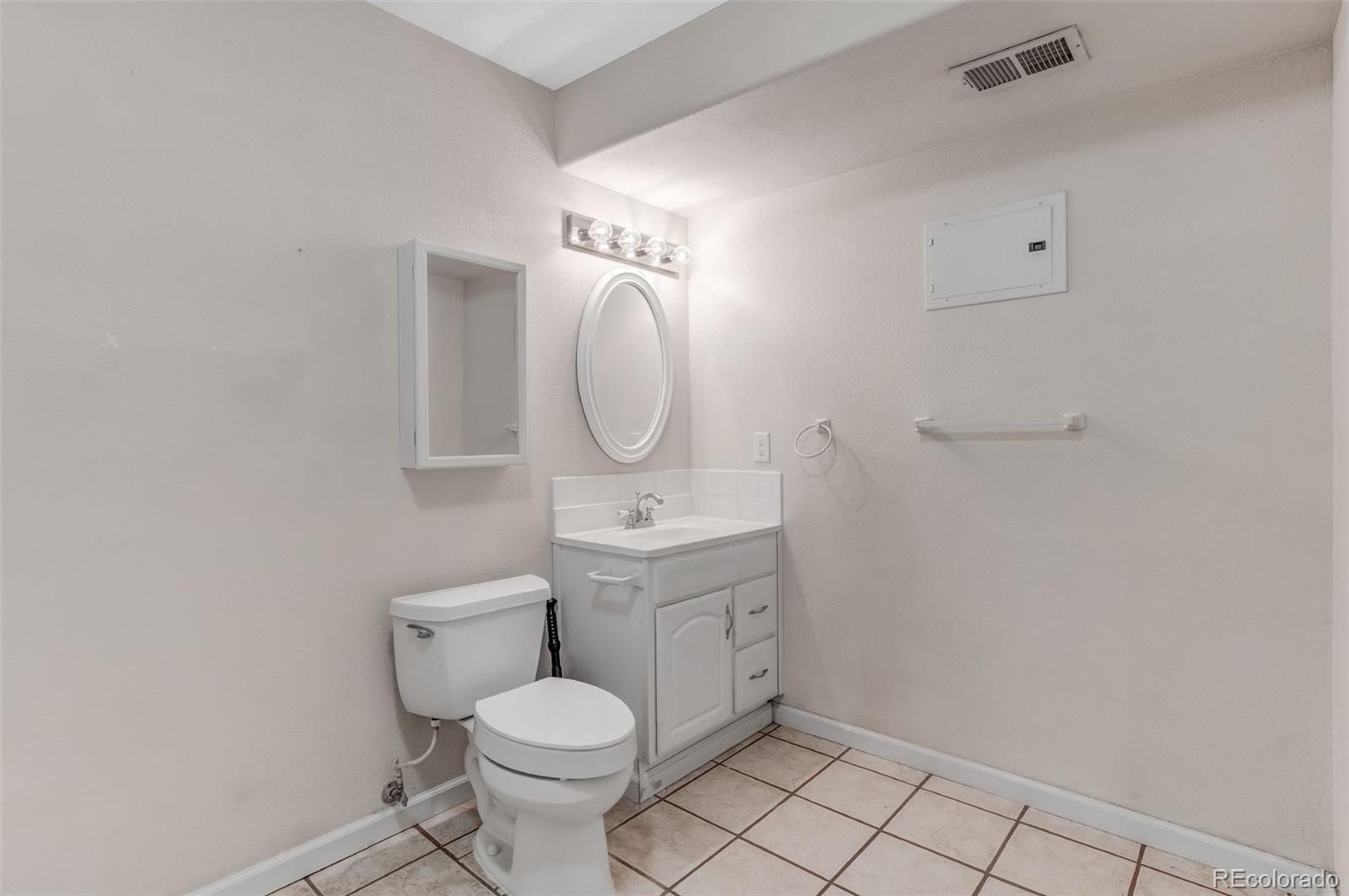 6656 South Reed Way, Unit B Littleton, CO 80123 - Photo 26 of 32 a bathroom with a toilet a sink and mirror