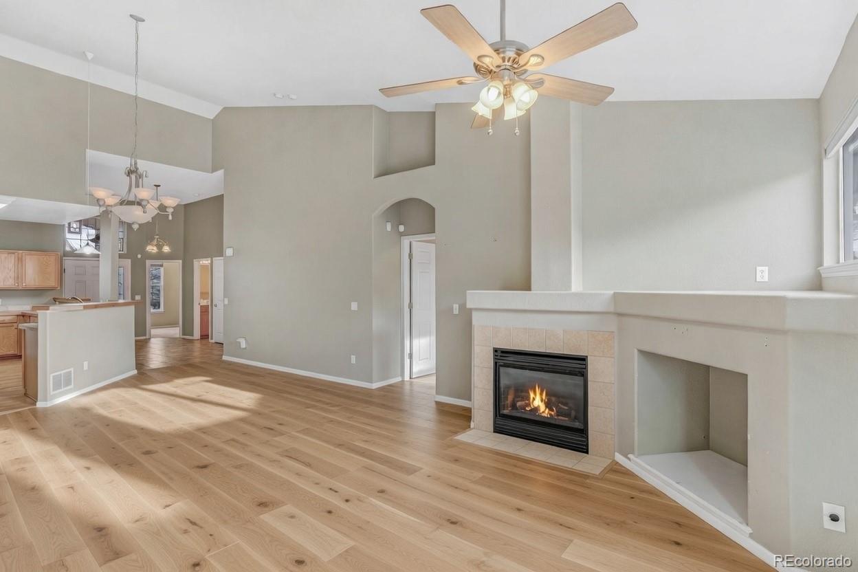 6656 South Reed Way, Unit B Littleton, CO 80123 - Photo 5 of 32 a view of a livingroom with a fireplace a chandelier fan and wooden floor
