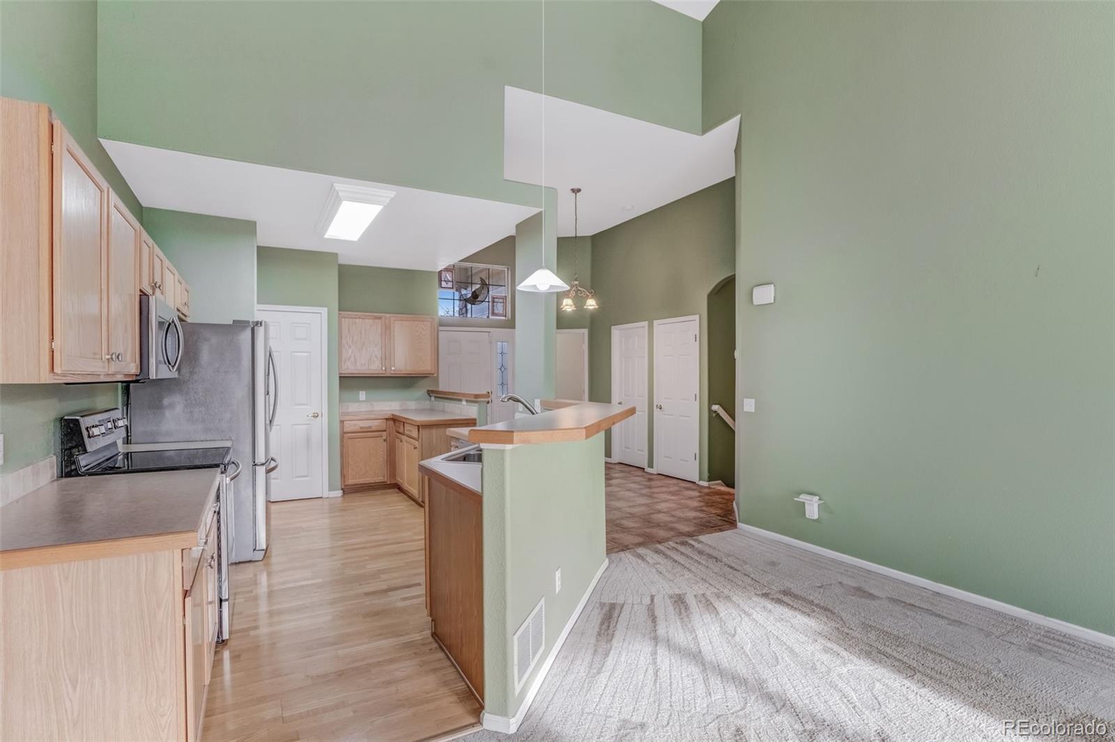 6656 South Reed Way, Unit B Littleton, CO 80123 - Photo 10 of 32 a kitchen with a sink cabinets stainless steel appliances and a counter top space