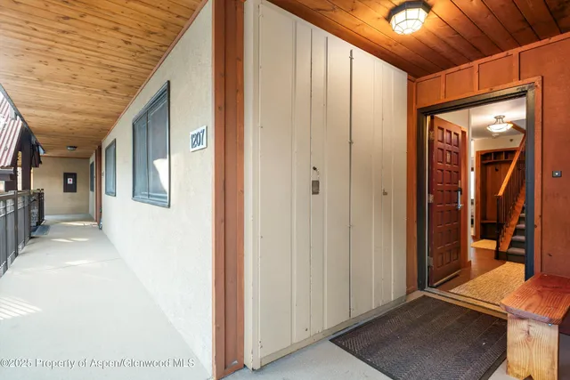 a view of a hallway with wooden floor and a living room