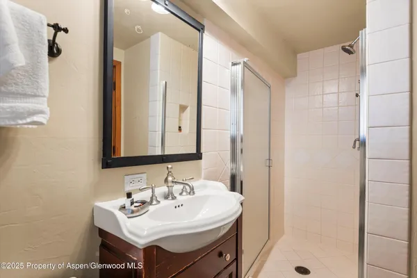 a bathroom with a sink mirror and shower