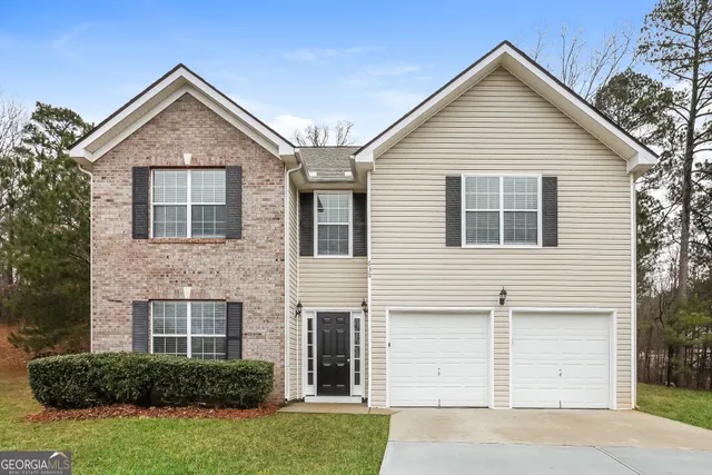 a front view of a house with a yard and garage