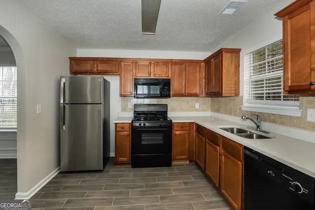 a kitchen with stainless steel appliances granite countertop a refrigerator stove and sink