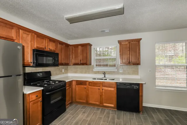 a kitchen with stainless steel appliances a sink dishwasher stove and oven