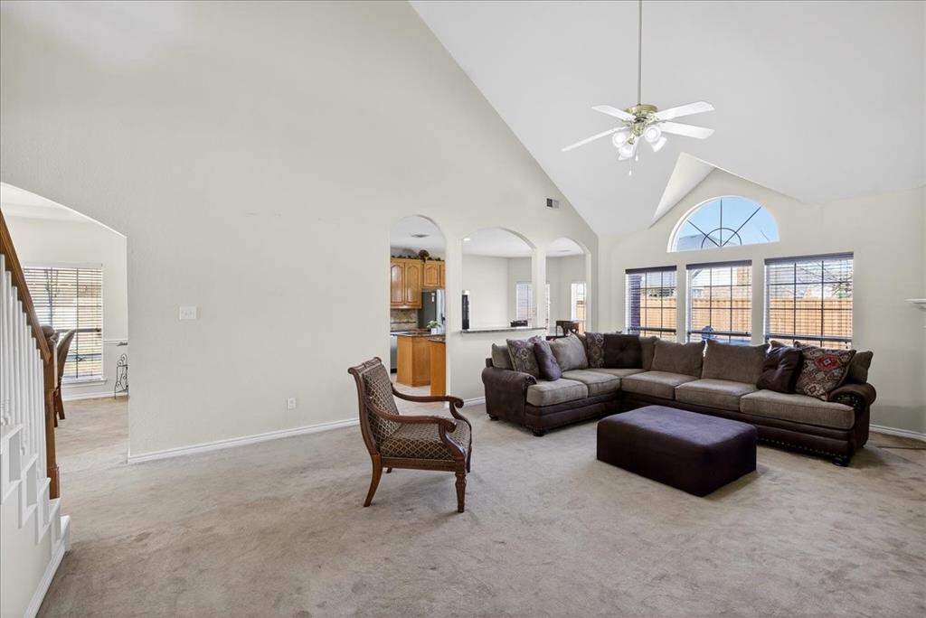 7308 Hawk Lane Sachse, TX 75048 - Photo 9 of 37 a living room with furniture a chandelier and a flat screen tv