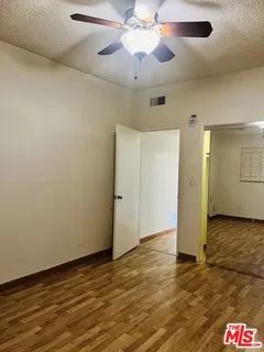 an empty room with closet and a chandelier fan