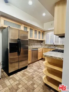 a kitchen with stainless steel appliances granite countertop a stove and a refrigerator