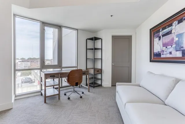 a living room with furniture and a floor to ceiling window