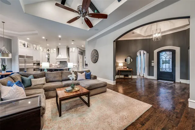 a room with wooden floor pool table and windows