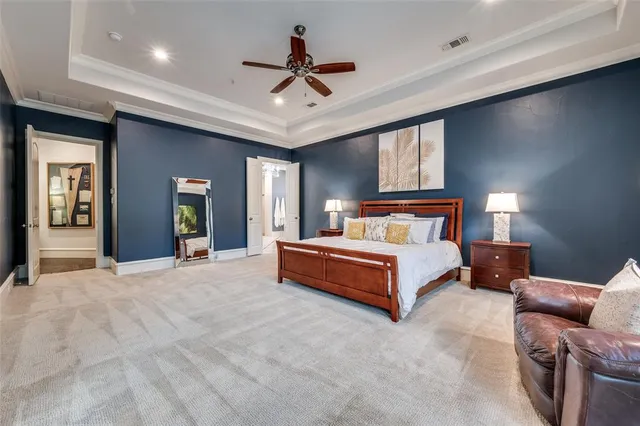 a spacious bedroom with a bed and ceiling fan