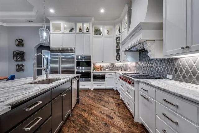 a large kitchen with stainless steel appliances kitchen island granite countertop a stove a sink dishwasher and a refrigerator