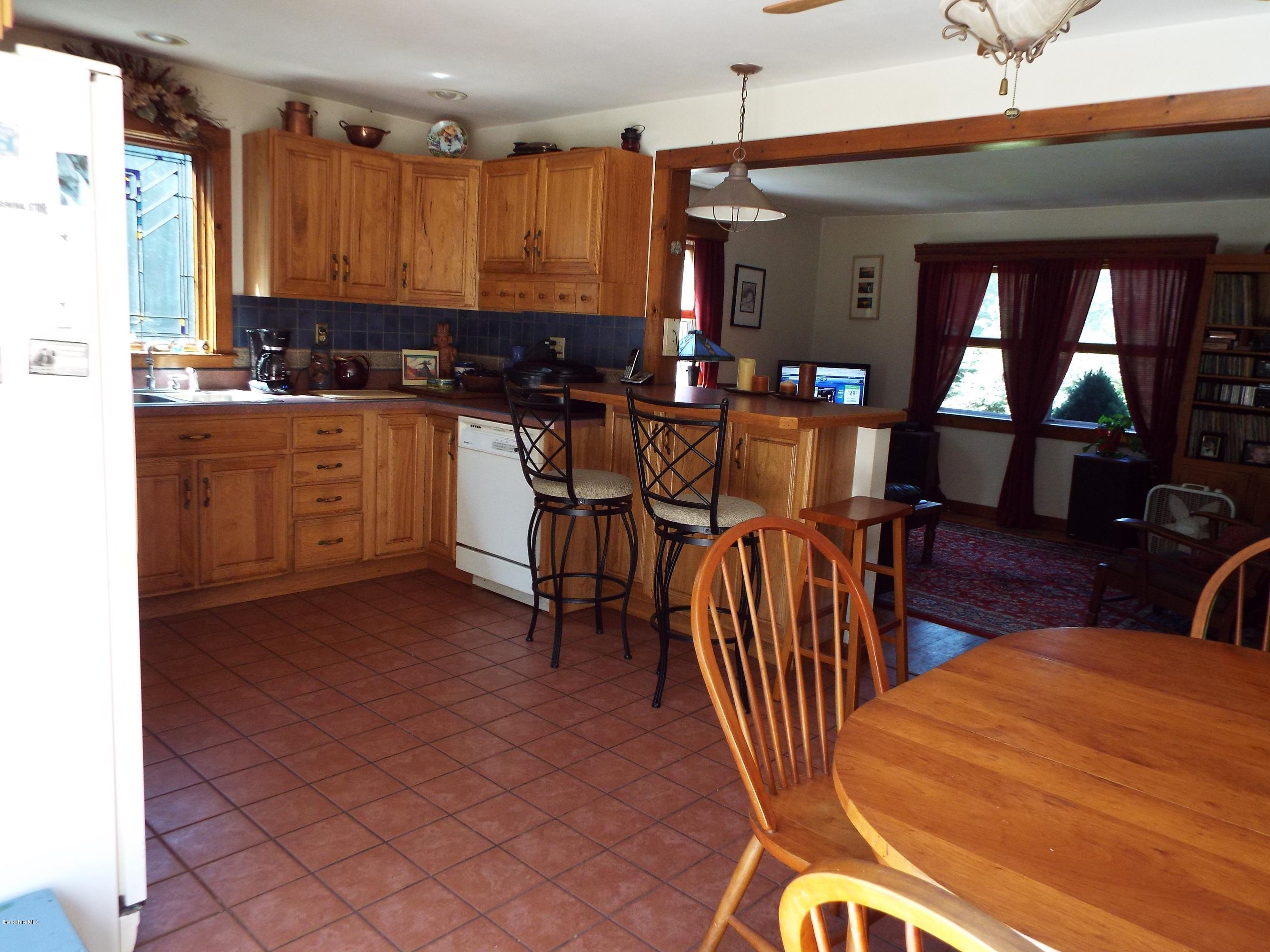 12 August Smith Road Peru, MA 01235 - Photo 4 of 11 a kitchen with stainless steel appliances granite countertop a stove a sink a dining table and chairs