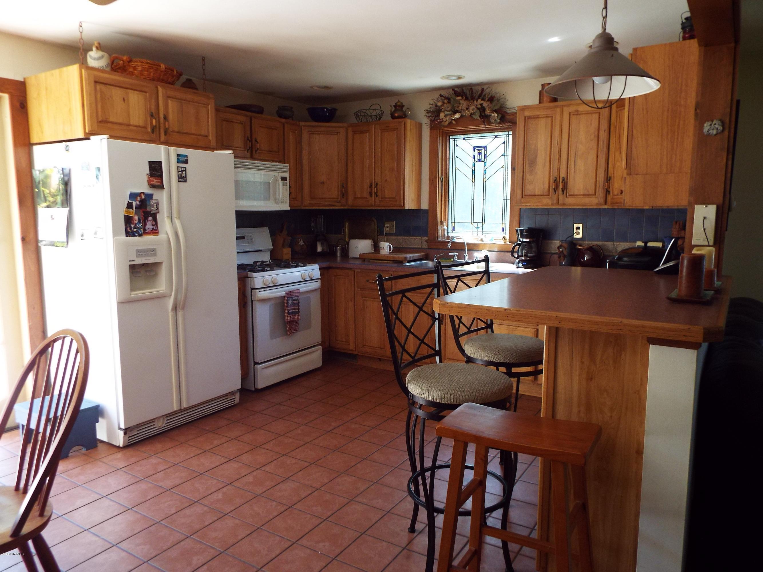 12 August Smith Road Peru, MA 01235 - Photo 5 of 11 a kitchen with a table chairs a refrigerator a sink a dining table and chairs