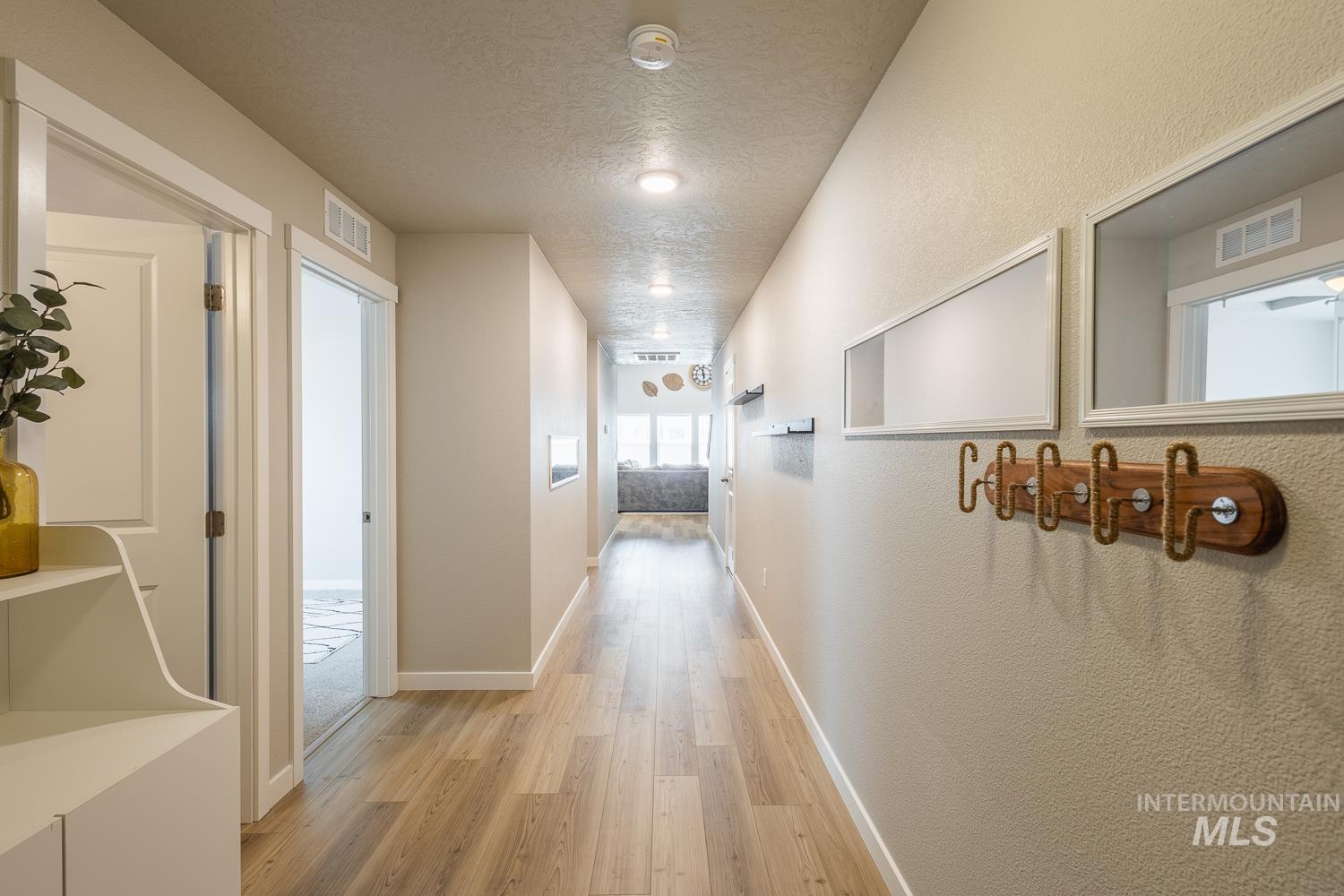 12623 Shadow Peak Street Caldwell, ID 83607 - Photo 7 of 50 Long hallway featuring wood-finish flooring, light-colored textured walls, and recessed lighting