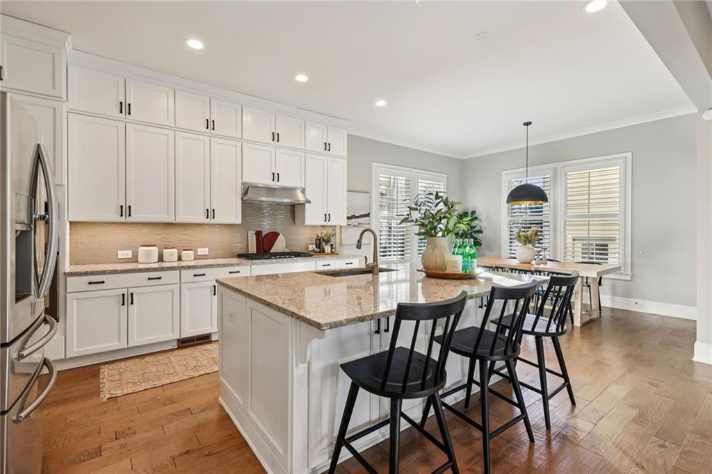 7345 Samples Field Road Cumming, GA 30040 - Photo 10 of 29 a kitchen with stainless steel appliances granite countertop a white cabinets and wooden floor