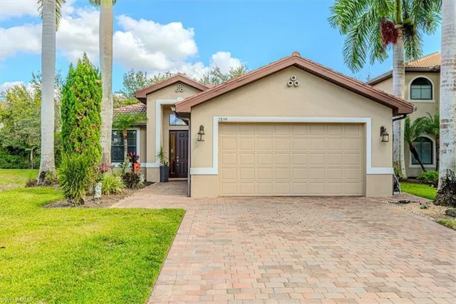 a front view of house with yard and palm tree