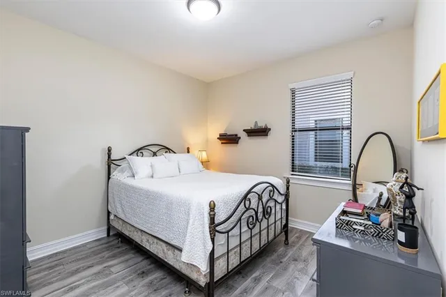 a bedroom with a bed and a dresser next to a window