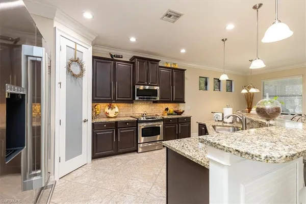 a kitchen with kitchen island granite countertop wooden cabinets and stainless steel appliances