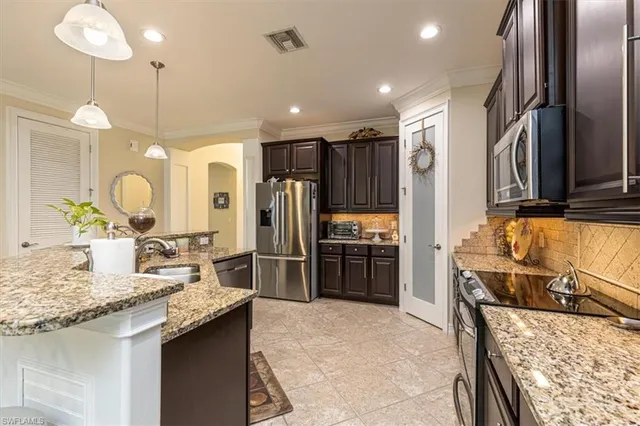 a kitchen with stainless steel appliances granite countertop a sink refrigerator and microwave
