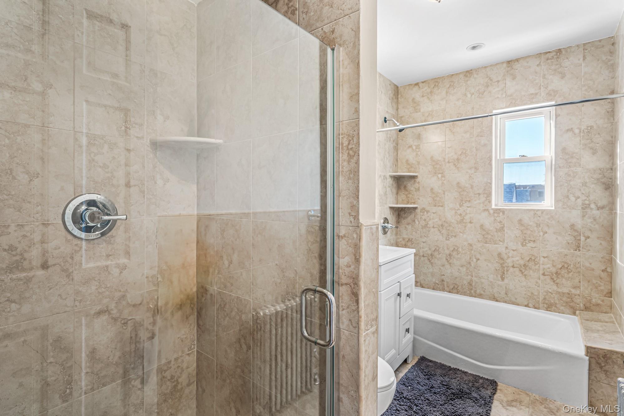 61-12 Main Street Queens, NY 11367 - Photo 23 of 35 Bathroom with vanity, a stall shower, and a bathtub