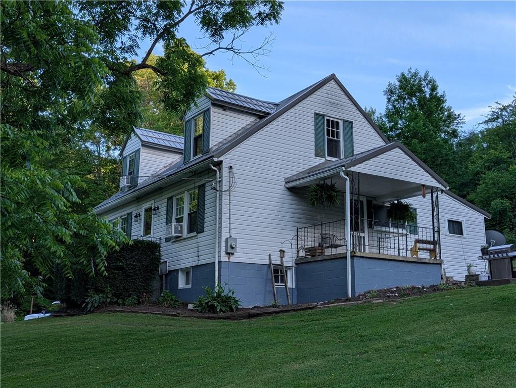 205 Woods Road Ligonier, PA 15658 - Photo 1 of 32 a front view of a house with a garden and plants