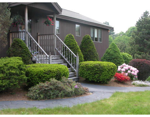 406 Boston Road Groton, MA 01450 - Photo 10 of 13 a view of a house with a flower garden in front of it
