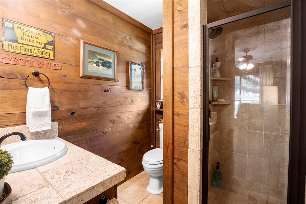 1516 Rancho Road Quinlan, TX 75474 - Photo 16 of 40 a bathroom with a granite countertop sink toilet and shower