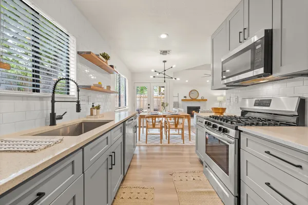 a kitchen with stainless steel appliances granite countertop a sink and stove top oven