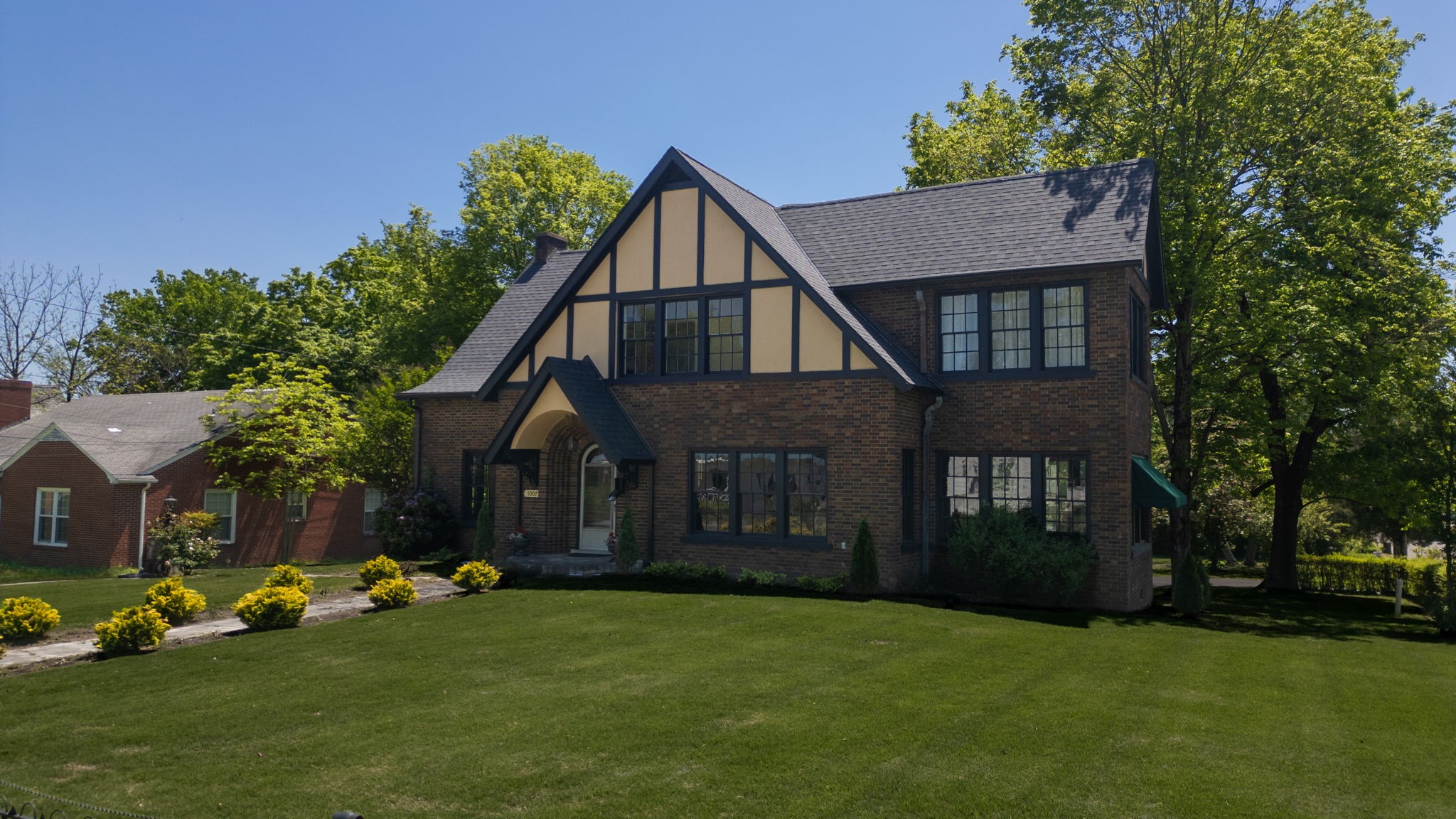 a front view of a house with a garden and trees