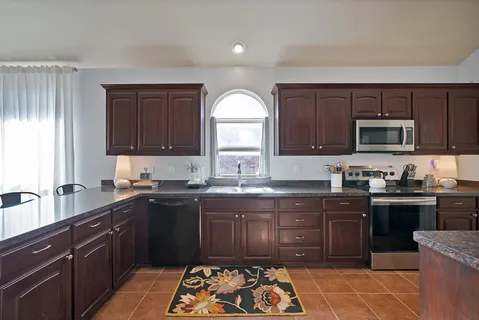 a kitchen with a sink stove top oven and microwave