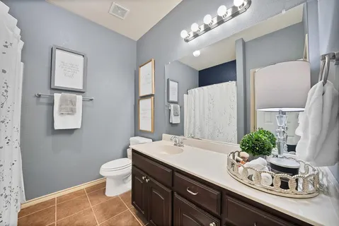 a bathroom with a double vanity sink mirror and toilet
