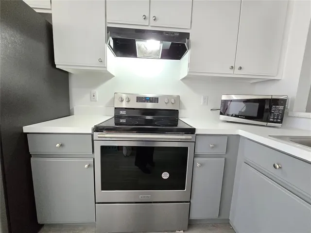 a stove top oven sitting inside of a kitchen