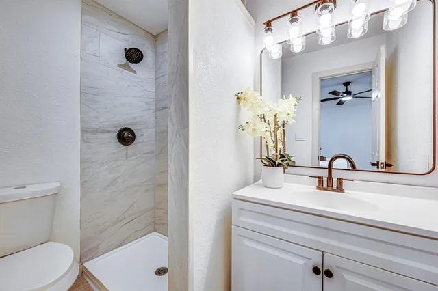 a bathroom with a sink a toilet and shower